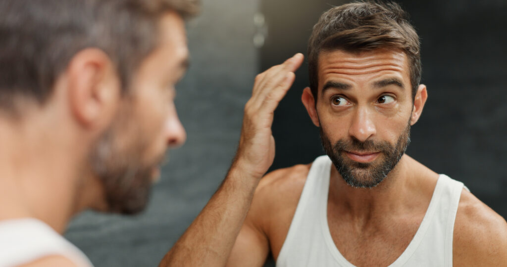 Man checking hair growth after finasteride use
